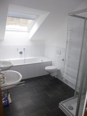 Tageslichtbadezimmer mit Badewanne und Dusche