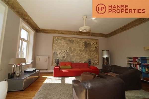 Wohnzimmer mit Kamin und restauriertem Stuck