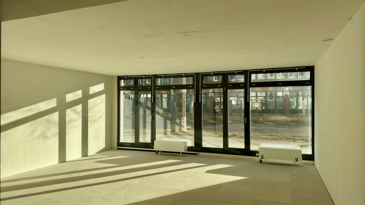 Fensterfront mit Jalousien und  Heizkörpern