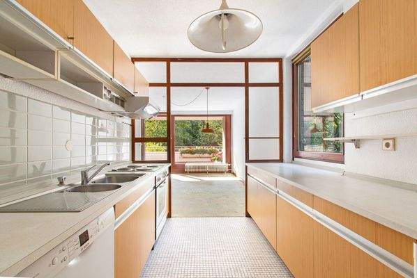 Helle Küche mit Einbauten und Zugang zum Essbereich