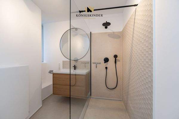 bodentiefer Dusche, schwarze Armaturen und strukturierte Fliesen -ein Hingucker 