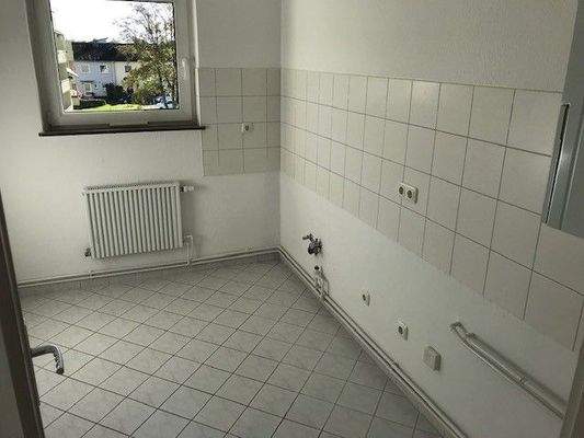 Küche mit Blick ins Grüne, weißem Fliesenspiegel und Bodenfliesen