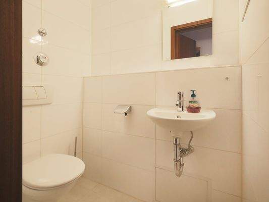 Modernes, hell gefliestes Gäste-WC