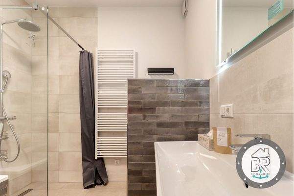 Badezimmer mit bodengleicher Dusche und stilvoller Ausstattung