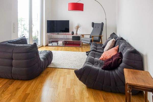 Gemütliches Wohnzimmer mit praktischer Raumaufteilung und bodentiefen Fensterelementen