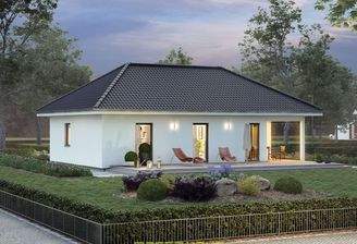 Stimmungsvoll beleuchteter Fertighaus Bungalow ComfortStyle von massa haus mit überdachter Terrasse,