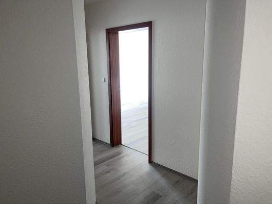 Heller Flur mit Holztür