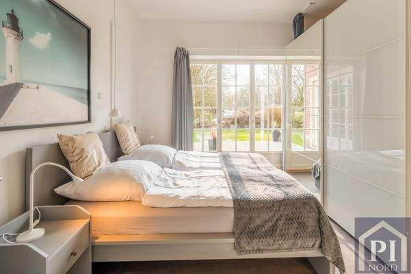 Schlafzimmer mit Terrassenzugang und Gartenblick