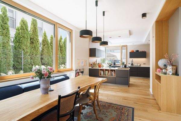 Offener Küchen- und Essbereich mit großen Fenstern neben dem Esstisch