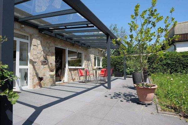 überdachter Sitzbereich auf der sonnigen Terrasse