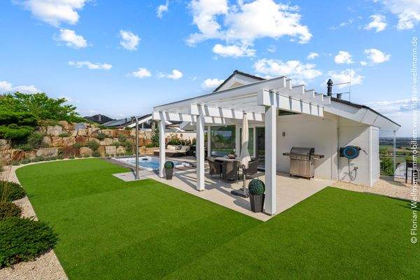 Terrassenflächen einheitlich mit großformatigen Fliesen, rund um den Pool stilvoll mit Bankirai-Holzbelag