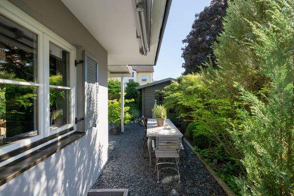 Charmanter Blick seitlich am Haus vorbei – mit Sicht auf den liebevoll gedeckten Esstisch