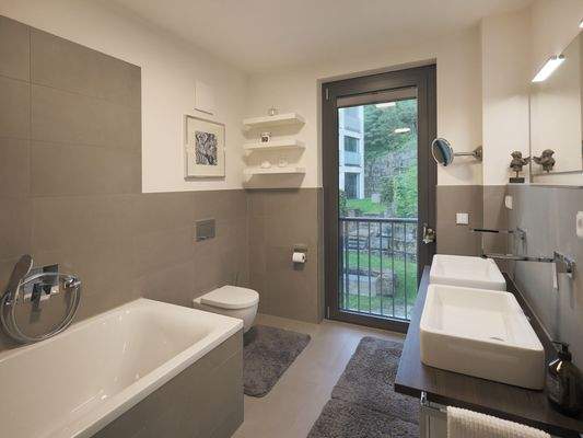 OG: Hochwertiges, modernes Badezimmer mit Doppelwaschtisch, Badewanne und WC