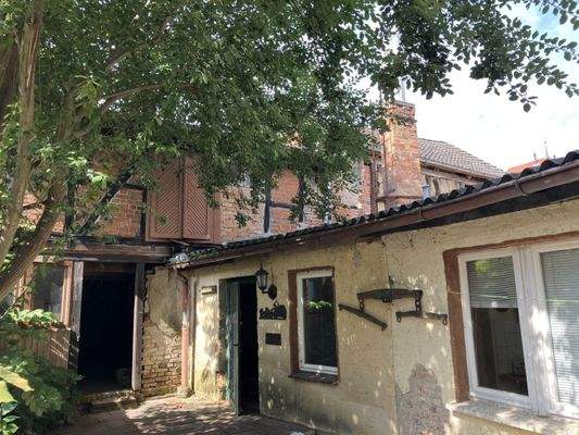 Hofseite mit Anbau und abrissreifem Nebengebäude im Hintergrund