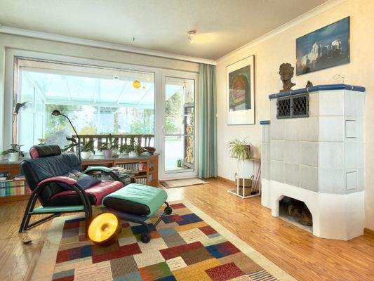 Wohnzimmer mit Kachelofen und  Zugang zur überdachten Terrasse