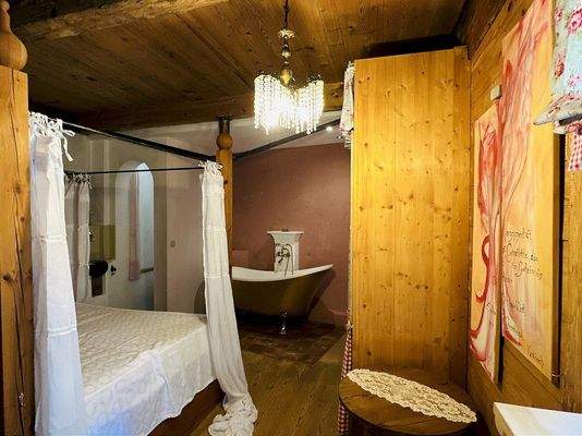 Schlafzimmer mit Badewanne und separatem WC