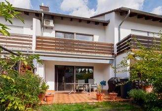 Gartenperspektive mit Terrasse und Balkon