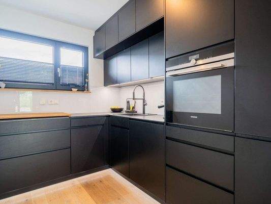 Dunkle Schreinerküche mit LED Beleuchtungskonzept