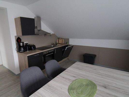 Die Küche mit Esstisch im OG