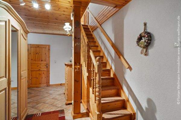 Diele (15,15m²) mit Echtholztreppe und Zugang zur Küche sowie drei weiteren Wohnräumen.