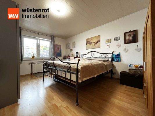 Einliegerwohnung: Schlafzimmer 1 in warmen Holztönen und gemütlichem Ambiente