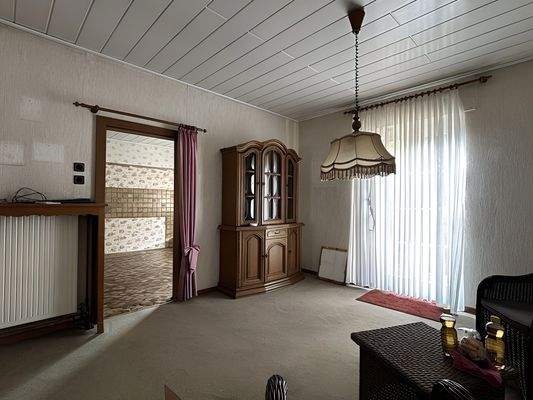 Zimmer mit Blick in die Küche und zur Außentür