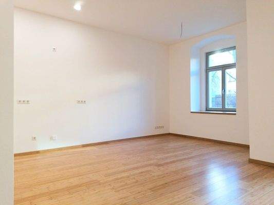 Wohnzimmer mit offener Küche und Fußbodenheizung