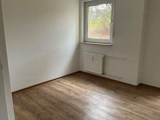 Zimmer mit Fenster und Bodenbelägen in Holzoptik.jpg