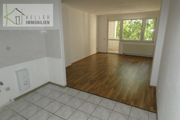 Großes Wohnzimmer mit Balkon und offener Küche