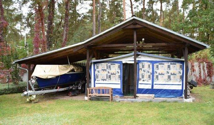 Boot und Zelt mit Wohnwagen unter dem Schleppdach