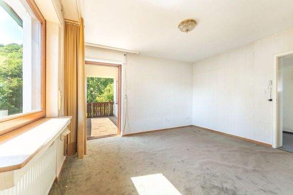 Zimmer mit Zugang zum Balkon im Obergeschoss