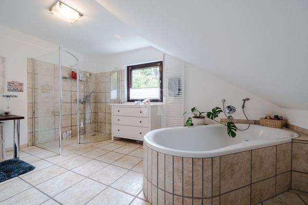 Stilvolles Badezimmer mit freistehender Wanne und großer Dusche