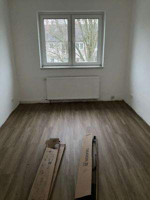 Zimmer mit Venylboden in Holzoptik und Fenstern.jpg
