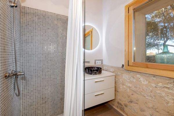 Bad mit Mosaikdusche und stilvollem Naturstein