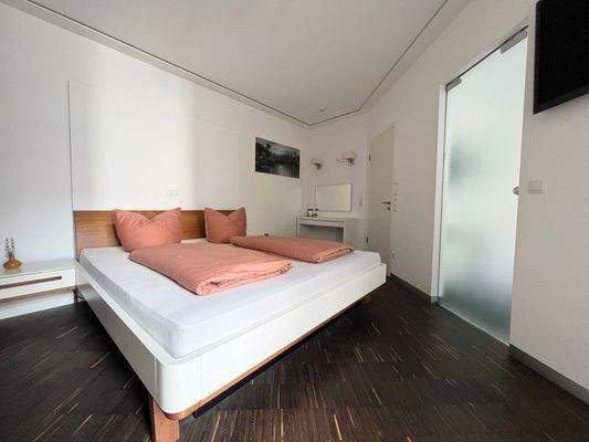 Charmantes Schlafzimmer mit indirekter Deckenbeleuchtung und eigenem Zugang zum Badezimmer 