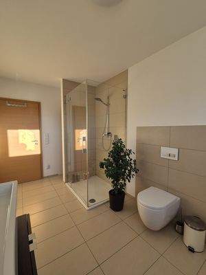 Modernes Tageslichtbad mit Dusche und Badewanne Perspektive 2