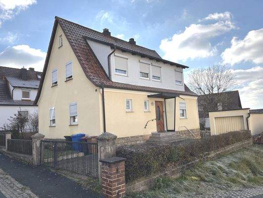 Nordostansicht des Hauses mit großer Dachgaube, Garage und Hauszugang