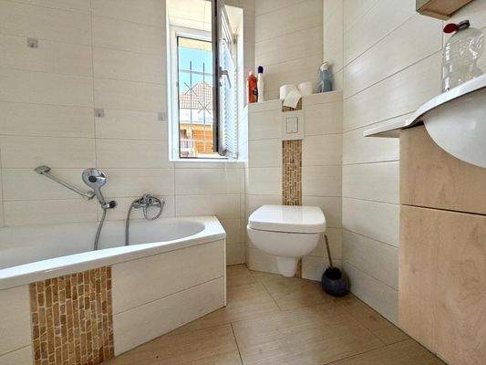 Badezimmer mit Badewanne und Dusche