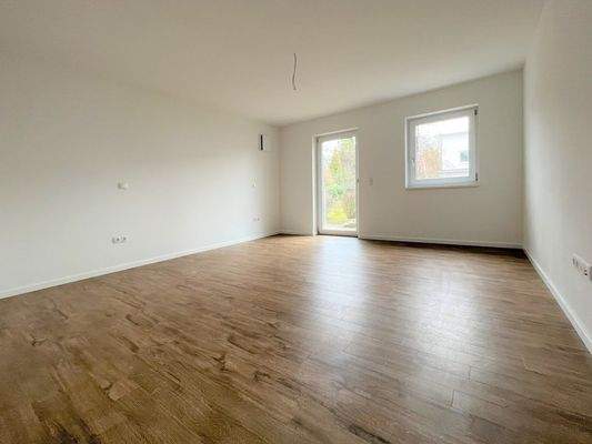 Lichtdurchfluteter Wohnraum mit hochwertiger Holzoptik-Bodengestaltung und großzügiger Fensterfront