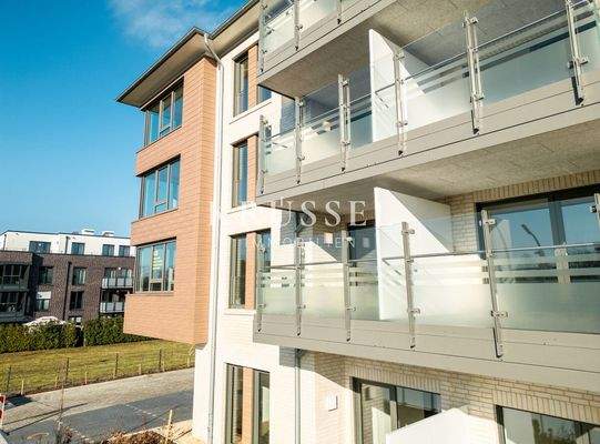 Die helle Fassade mit südlich ausgerichteten Glasbalkonen und Terassen.