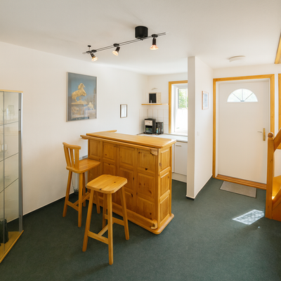 Helles Wohnzimmer mit Heimbar und Treppe.png