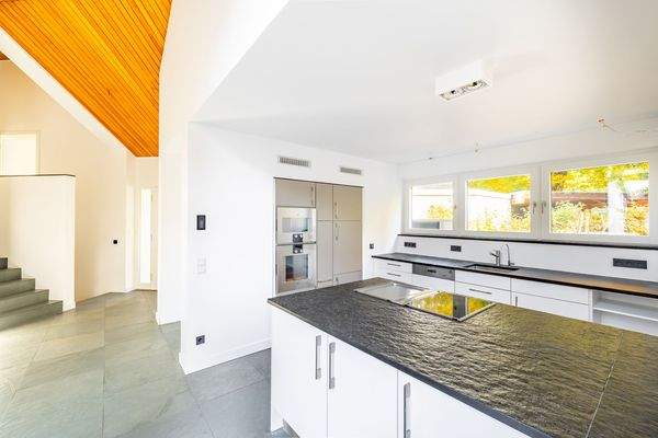 Die offene Küche mit edlem Küchenblock und Naturst