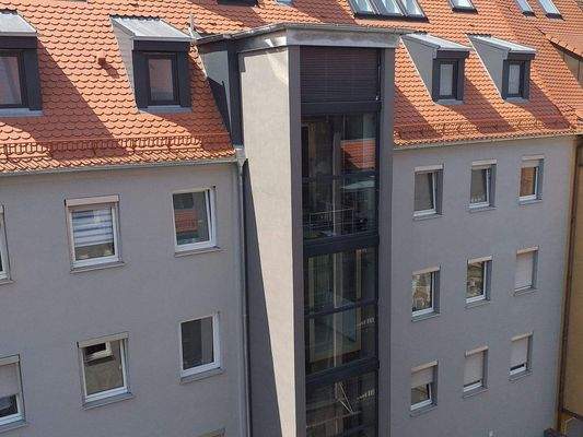 Gebäuderückseite mit verglastem Aufzug