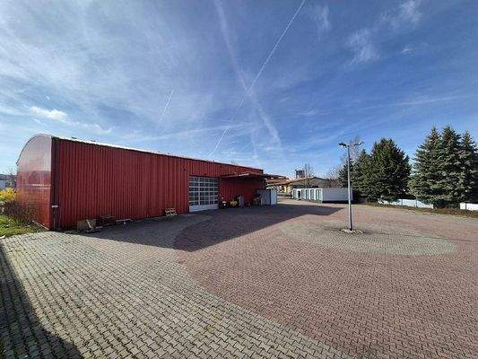 Rückansicht mit Rolltor und Freifläche