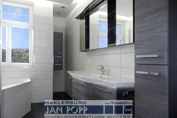 Tageslichtbad mit Eckwanne, Duschkabine und Badmöbeln 