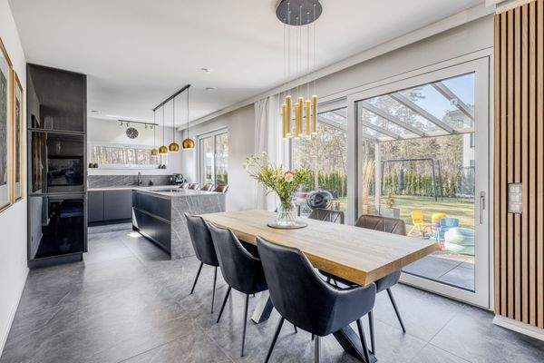 Offener Wohn- und Essbereich mit Designküche und bodentiefen Fensterfronten