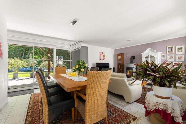 Wohnraum mit Esstisch, Couch und Kamin