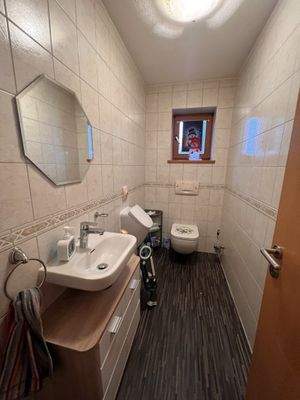 Helles Badezimmer mit praktischem Waschtisch und WC, durchdachte Raumaufteilung