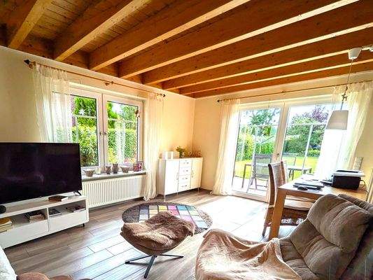 Das Wohnzimmer der kleineren Wohnung hat einen Zugang zu Terrasse und Garten