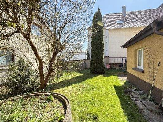 Kleiner Garten hinterm Haus mit Anbau